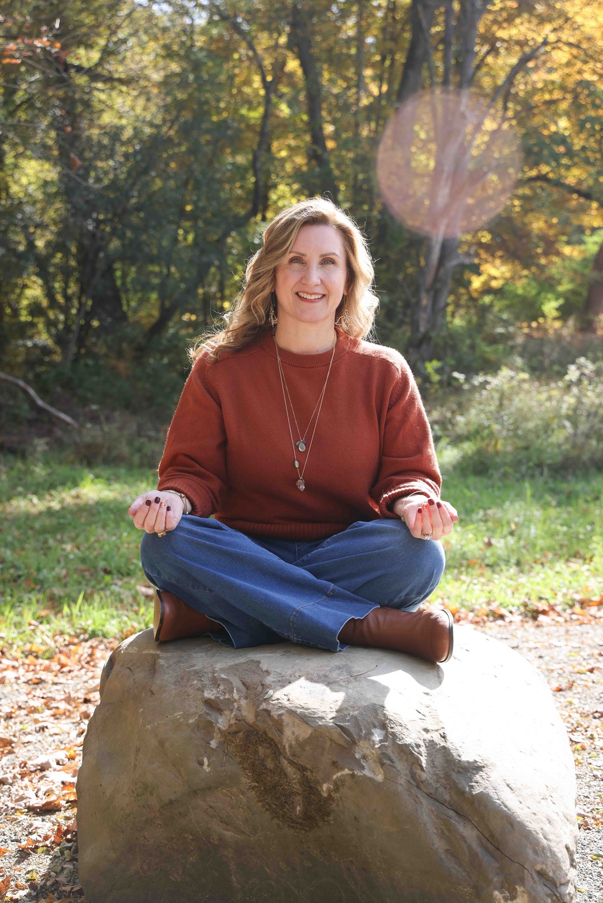 Christine Dorsey meditating on a rock in autumn light